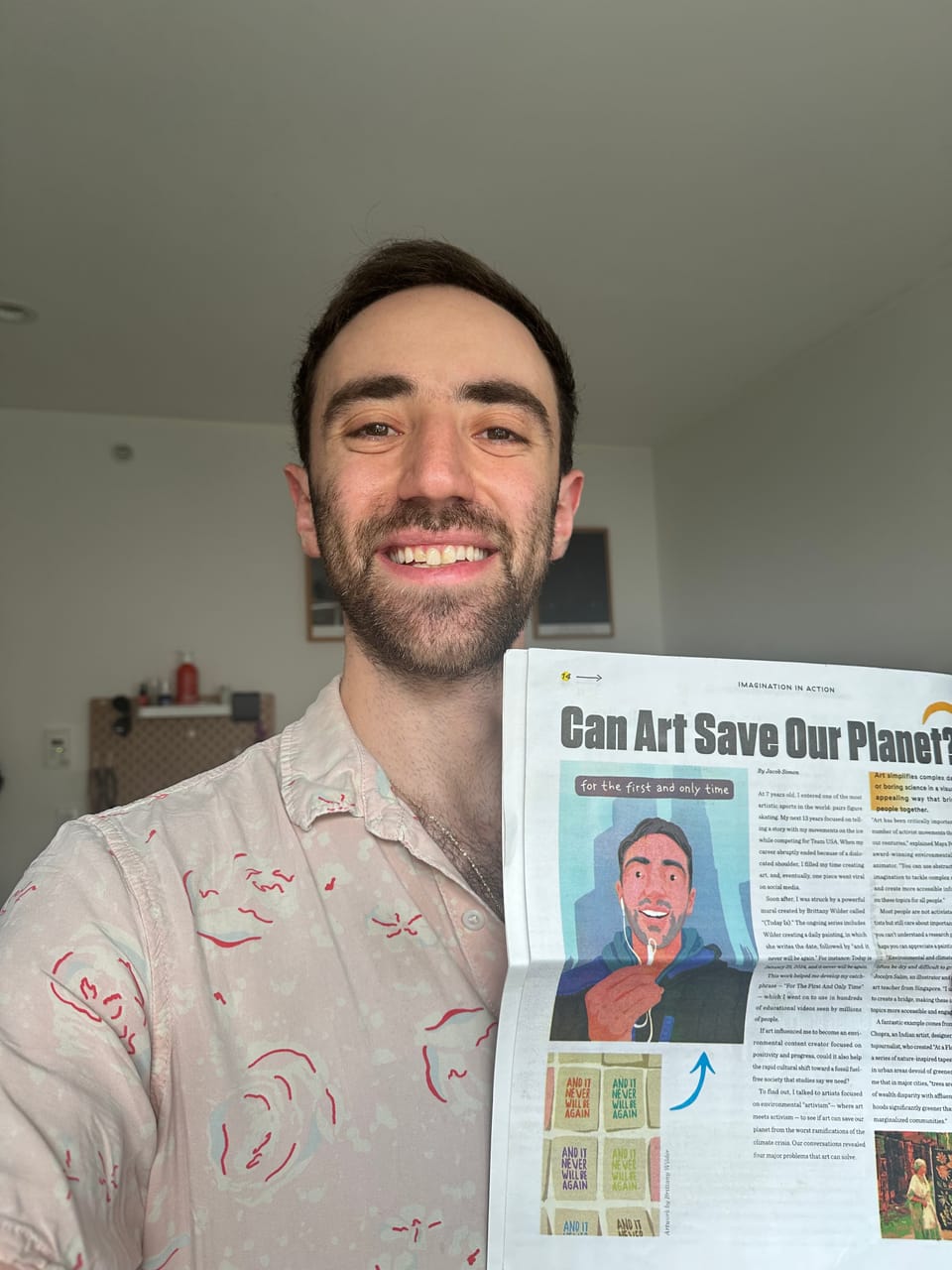 Jacob smiling and holding a newspaper